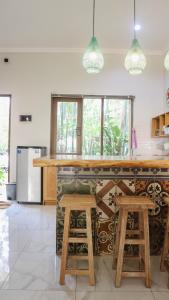 a kitchen with a counter with stools and a counter top at Villa Gardenia Pantai Jepara in Jepara