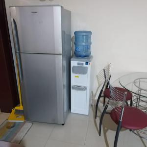 Il comprend une cuisine équipée d'un réfrigérateur, d'une table et de chaises. dans l'établissement العين الهيلي مصباح بيت 8, à Al-Aïn