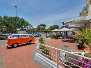 an orange and white van parked in a parking lot at Spacious family Apartment Near Beach with Inverter in Cape Town