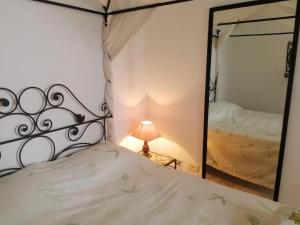 1 dormitorio con cama y espejo grande en JARDIN Apartments, en El Aouina