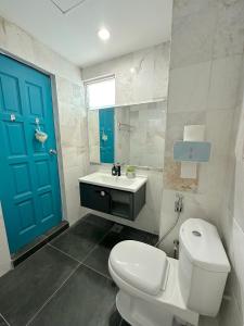 baño con aseo blanco y puerta azul en Blue Andaman Seaview Families Suite Apartment, en Kuah