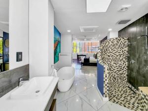 a bathroom with a tub and a toilet and a sink at Spacious family Apartment Near Beach with Inverter in Cape Town