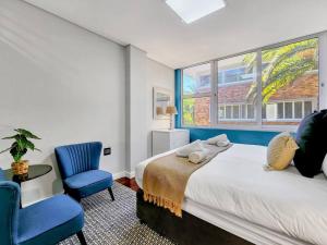 a bedroom with a bed and a chair and a window at Spacious family Apartment Near Beach with Inverter in Cape Town