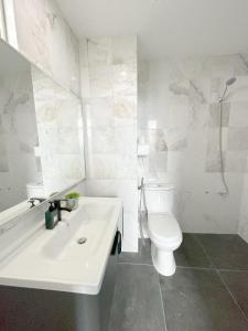 uma casa de banho branca com um WC e um lavatório em Blue Andaman Seaview Families Suite Apartment em Kuah