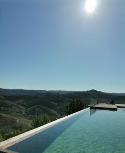 a swimming pool with a view of the countryside at Quinta de Travassinhos- Douro Valley in Santa Marta de Penaguião