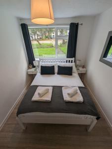 a bedroom with a large bed with two towels on it at Pet Friendly 2 Bed Coastal Property - Millendreath, Looe in Looe