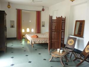 a bedroom with a bed and a table and chairs at Silver Moon Haveli in Udaipur