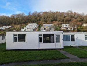 a white house on a hill with apartments at Pet Friendly 2 Bed Coastal Property - Millendreath, Looe in Looe