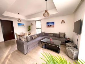 a living room with a couch and a table at Luxurious Golf & Sea View Beach Apartment with Pool Access - Cocon de Taghazout Bay in Taghazout