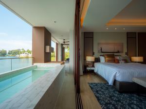 a bedroom with a large bed and a swimming pool at Luxury apartments in the Laguna near the lake in Bang Tao Beach