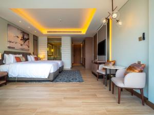 um quarto de hotel com uma cama, uma mesa e cadeiras em Luxury apartments in the Laguna near the lake em Praia de Bang Tao