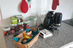 a kitchen counter with a basket of food and a coffee maker at A Caminho da Ilha in Ponta Delgada