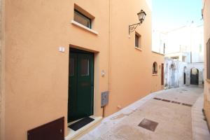 una puerta verde al lado de un edificio en Dimora San Leuci, en Gagliano del Capo