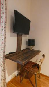 a computer desk with a monitor and a chair at Sonnhof in Sankt Gilgen