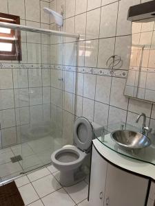 a bathroom with a shower and a toilet and a sink at Casa prox á praia e aeroporto in Florianópolis