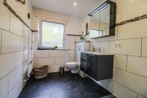 a bathroom with a toilet and a sink and a window at Sweet Six, Sauna, Balkon, Netflix, Boxspringbetten, hochwertiges Bad in Zell an der Mosel +26 photos