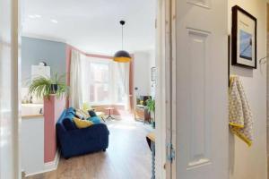 a living room with a blue couch and a window at The Little Place By The Sea in Kent