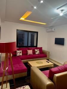sala de estar con sofá rojo y mesa en Studio de luxe, en La Soukra
