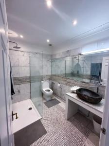 a bathroom with a sink and a toilet and a shower at Homestay - En-suites in New Malden