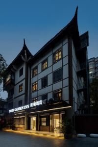 a building with a sign on the side of it at Xishu Garden Inn - Travel Agency service - Car Rent service - English Speaking in Chengdu