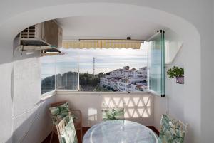 ein Esszimmer mit einem Glastisch und einem Fenster in der Unterkunft Benalmarina in Benalmádena