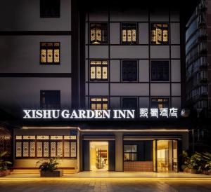 Xishu Garden Inn في تشنغدو: مبنى فيه لوحة مكتوب فيها حديقة شيشة