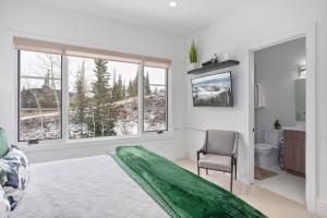 a bedroom with a bed and a chair and windows at Quicksilver Haus in Park City