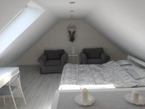 a bedroom with a bed and couches in a attic at Domek dwupoziomowy in Jarużyn