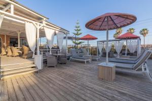 a deck with chairs and umbrellas on a building at Villas D. Dinis - Charming Residence (adults only) in Lagos