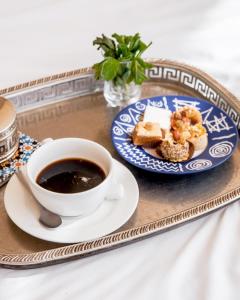 a cup of coffee and a plate of food on a tray at Emeraude Camp Agafay in El Karia