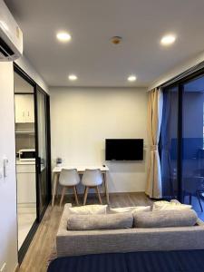 a living room with a couch and a table at Cozy 1-bedroom Apartments in Laguna Skypark Bang Tao in Phuket Town