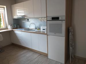 a kitchen with white cabinets and a sink at Domek dwupoziomowy 