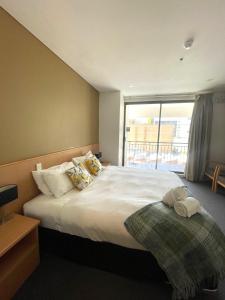 een slaapkamer met een groot wit bed en een raam bij 408 Abundant Abode Cbdpad Best Location in Perth