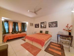 1 dormitorio con 2 camas y mesa en Vijaya's Homestead Jaipur, en Jaipur