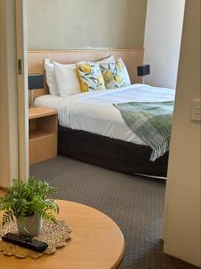 een slaapkamer met een bed en een tafel bij 408 Abundant Abode Cbdpad Best Location in Perth