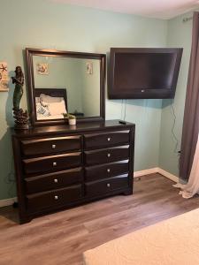 a dresser with a mirror and a television on it at La Adventura Villa in Seminole
