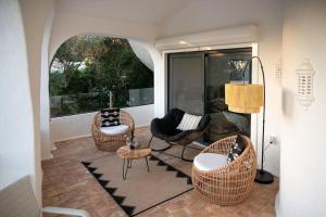 sala de estar con sillas de mimbre y mesa en Villa Eloah - Magnifique villa portugaise rénovée vue mer, en Carvoeiro