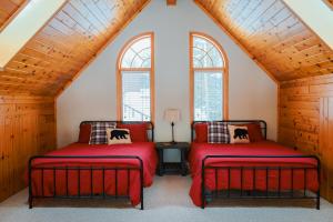 two beds in a attic room with windows at The Loonstar Lodge On Rabbit Lake in Crosby