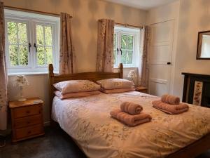 - une chambre avec 2 serviettes sur un lit et des fenêtres dans l'établissement Forestry Cottage. Hot tub, open fire, dog friendly, à Gaywood