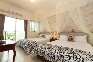 Un dormitorio con dos camas y una ventana en 海洋柔情-旅遊補助-日租 包棟-親子 寵物友善 溜滑梯 海洋公園 沙灘車 天空之鏡, en Jian