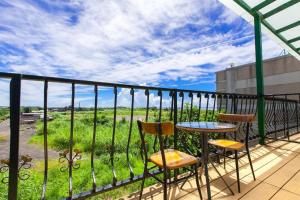 Un balcón con dos sillas y una mesa con vista. en 海洋柔情-旅遊補助-日租 包棟-親子 寵物友善 溜滑梯 海洋公園 沙灘車 天空之鏡, en Jian 31 fotos más