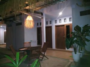 a room with a table and chairs and a chandelier at Merendeng Hostel Kuta in Kuta Lombok