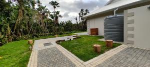 un jardín con bancos y un tanque de agua junto a una casa en Caribbean Estates Villa Varie - Brand new Villa - est December 2023!, en Port Edward