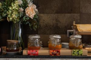 a table with jars of honey and a vase of flowers at Villas D. Dinis - Charming Residence (adults only) in Lagos