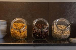 three glass containers filled with different types of food at Villas D. Dinis - Charming Residence (adults only) in Lagos
