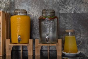two glass jars of orange juice on wooden stands at Villas D. Dinis - Charming Residence (adults only) in Lagos