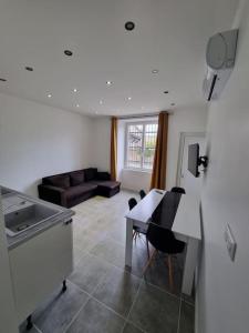 Appartement neuf 36m2 climatisé في Chamaret: مطبخ وغرفة معيشة مع طاولة وأريكة