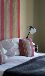 a bed with a lamp and two pillows on it at The Pier Hotel in Harwich