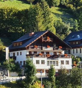 ein großes weißes Haus mit schwarzem Dach in der Unterkunft Appartements DIANA in Bad Kleinkirchheim