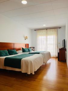 een grote slaapkamer met een groot bed met groene lakens bij Las Palmeras in Crevillente